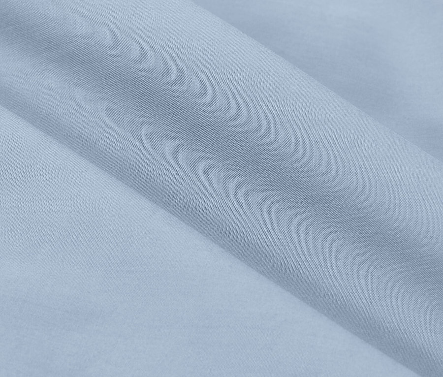 Detailní záběr světle modré látky s jemnými záhyby.