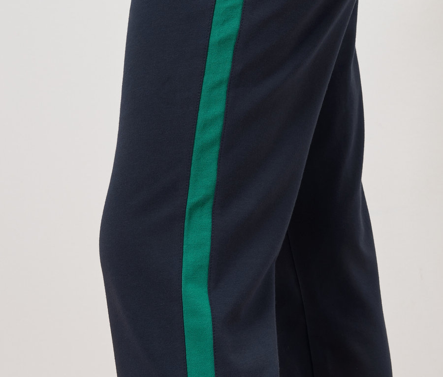 Detail nohavic s tmavě modrým pozadím a zeleným pruhem na boku.