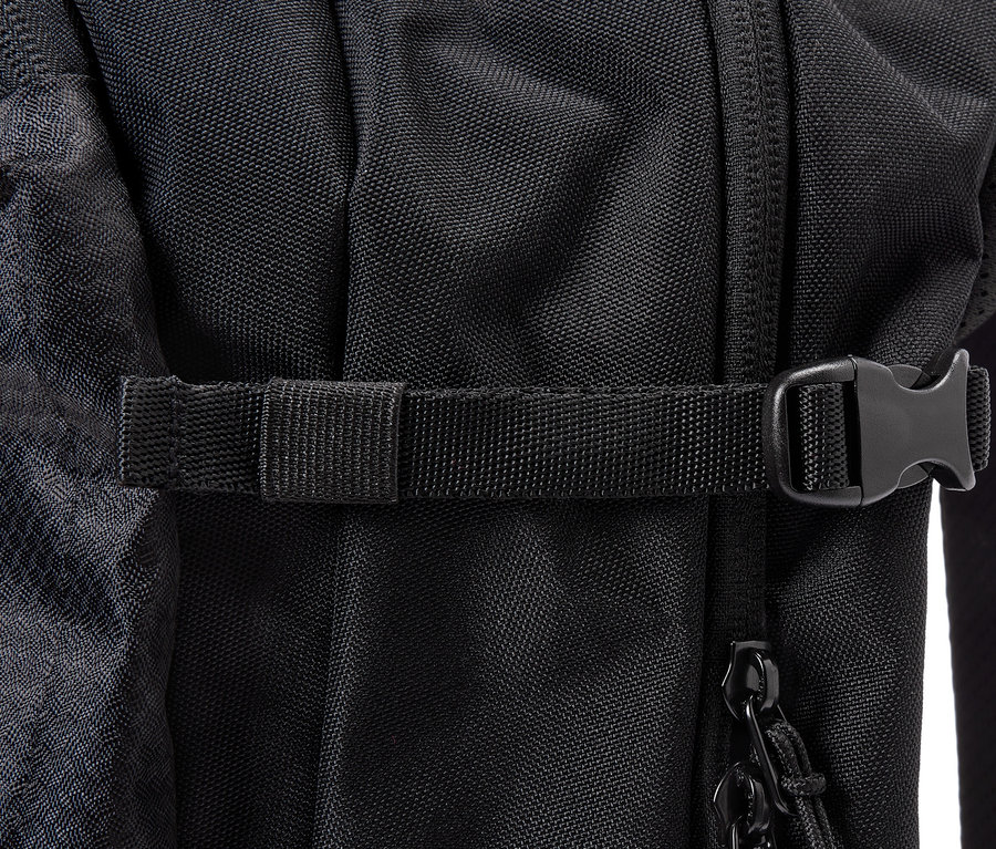 Detailní pohled na černý batoh s popruhem a sponou.