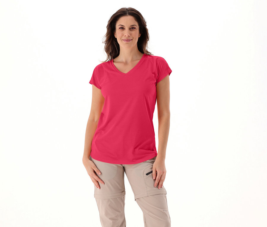 Žena má na sobě růžové dámské tričko s výstřihem do V CMP a béžové kalhoty na bílém pozadí.