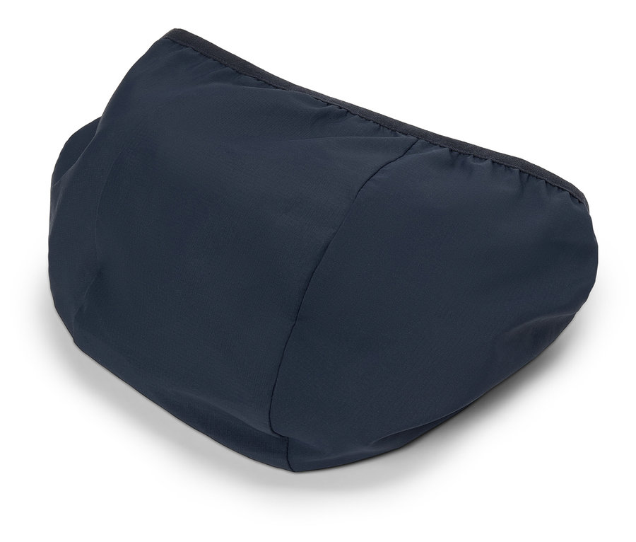 Detailní záběr na tmavě modrou kapuci s černým lemem ležící na bílém povrchu.