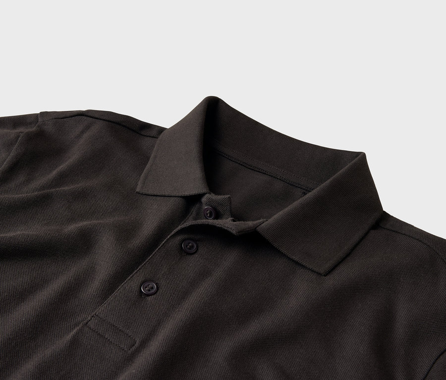 Detailní záběr na tmavě hnědé polo tričko s límečkem a dvěma knoflíky.