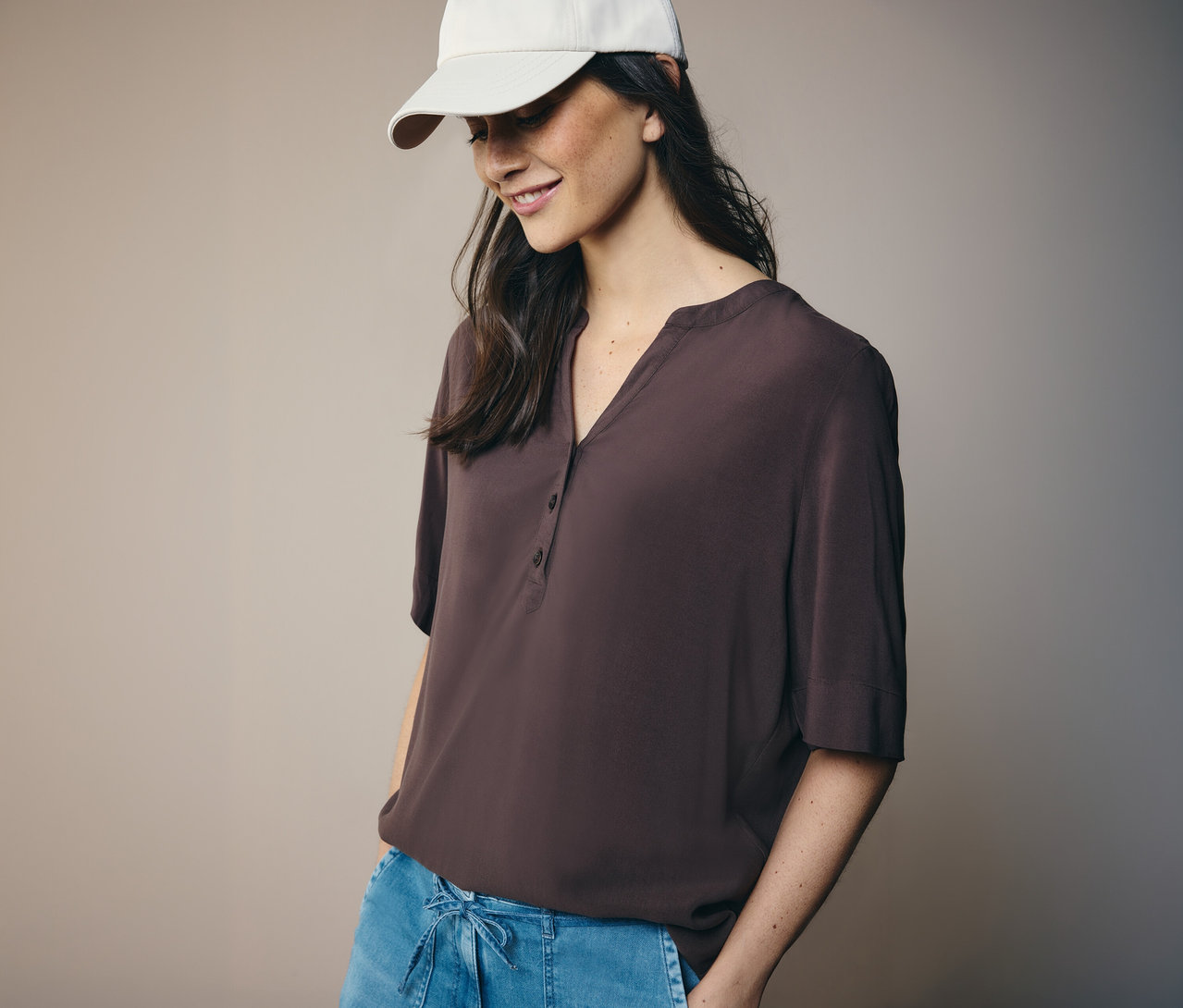 Žena v bílé čepici a hnědé tunikové halence CECIL.