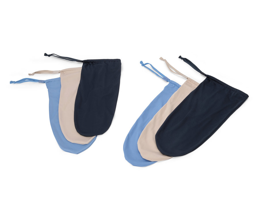 Tři látkové sáčky se stahovací šňůrkou v modré, béžové a černé barvě leží na bílém pozadí.