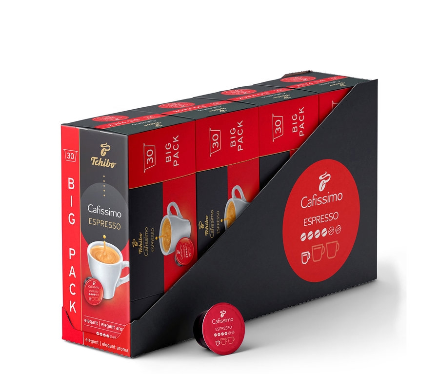 Černý stojan s červeno-černými baleními 'Tchibo Cafissimo Espresso BIG PACK 30', každé s obrázkem bílého šálku espressa. Před stojanem leží jedna červená kapsle 'Cafissimo Espresso'.
