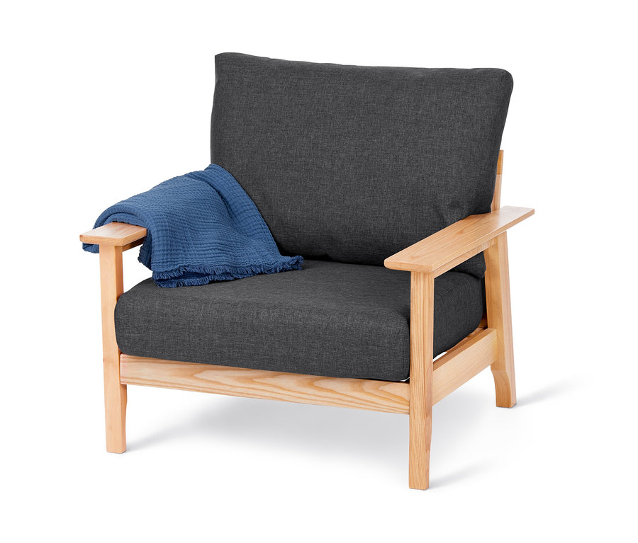 Křeslo z masivního jasanového dřeva s certifikací FSC® s šedým sedákem a modrou dekou.