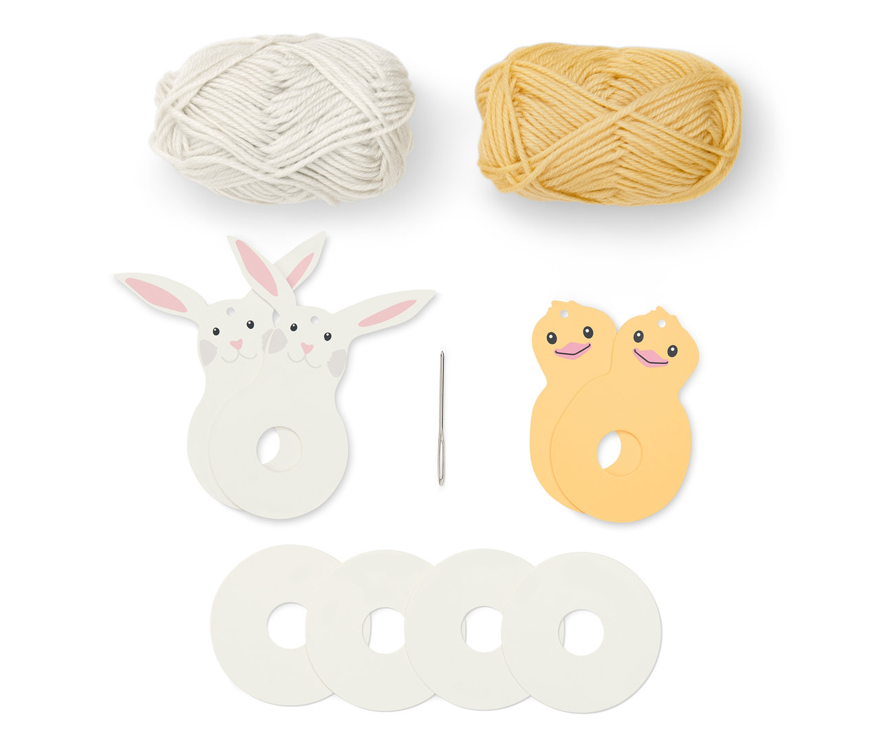 Bílý a žlutý klubko vlny, jehla a díly velikonoční sady střapců.