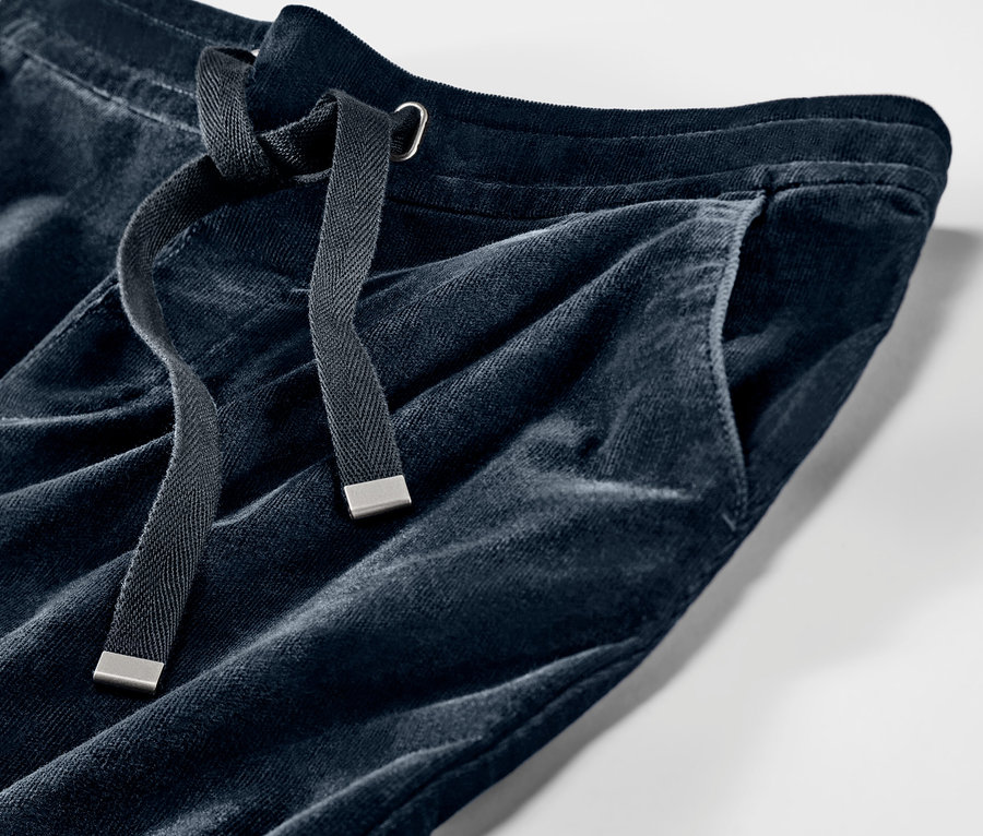 Detailní záběr na manšestrové kalhoty joggpant. Kalhoty mají stahovací šňůrku a kapsu.