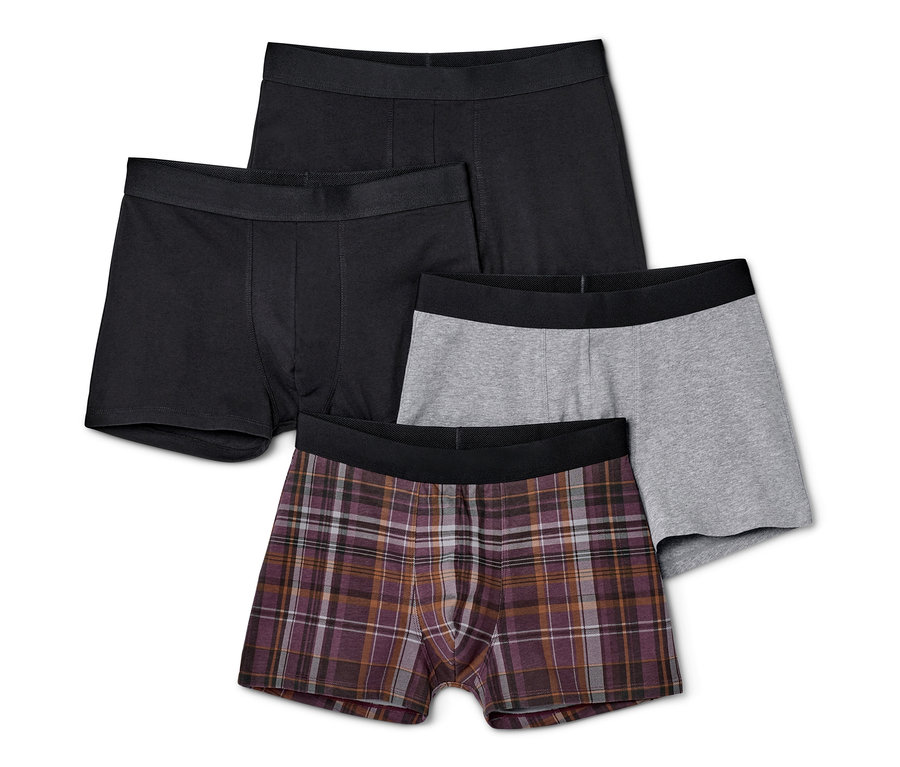 Čtyři kusy boxerek: dvoje černé, jedny šedé a jedny kostkované.
