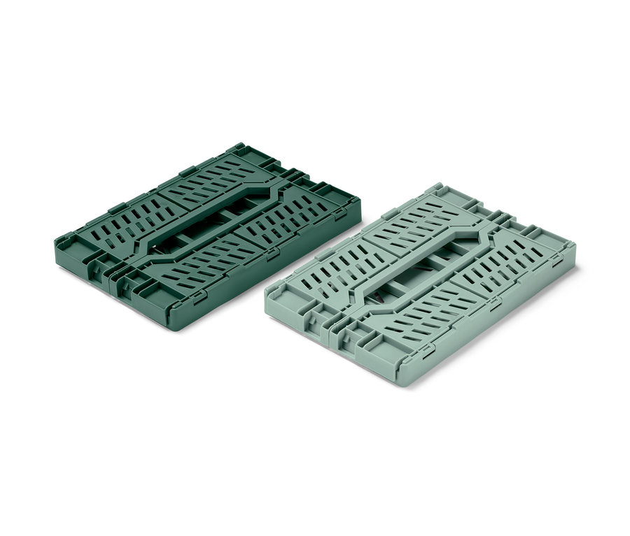 Dvě skládací úložné bedýnky, jedna tmavě zelená a jedna světle zelená, jsou složené na bílém pozadí.