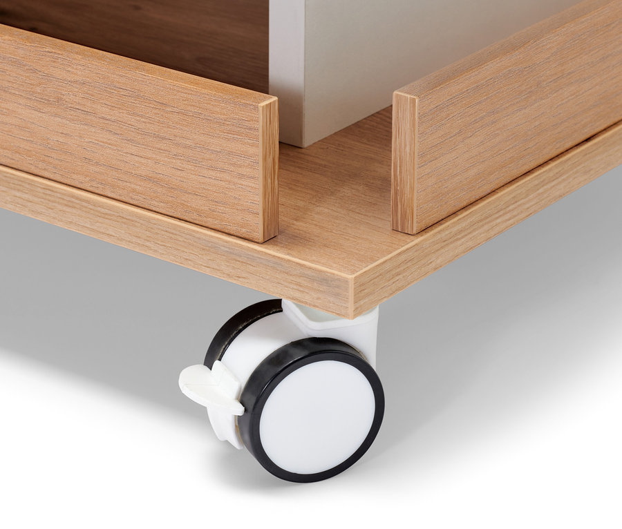 Detail věžového regálu s úložným prostorem, zobrazující kolečko a dřevěnou konstrukci.