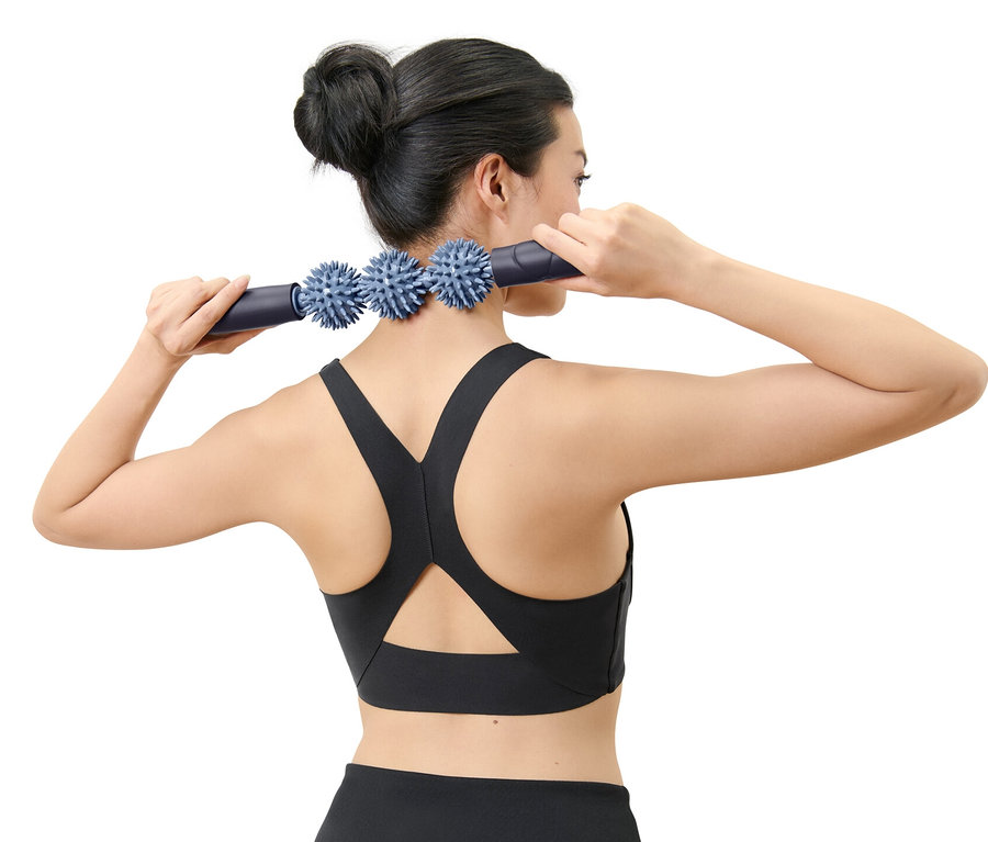 Žena používá pomůcku na masáž fascií na krku.