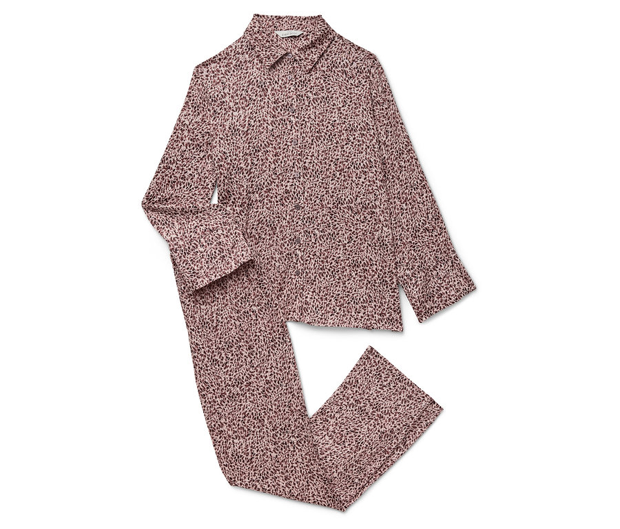 Růžové pyžamo s dlouhým rukávem a kalhotami s potiskem leží na bílém pozadí.