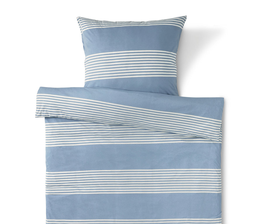 Modré povlečení s bílými pruhy a polštář nahoře.