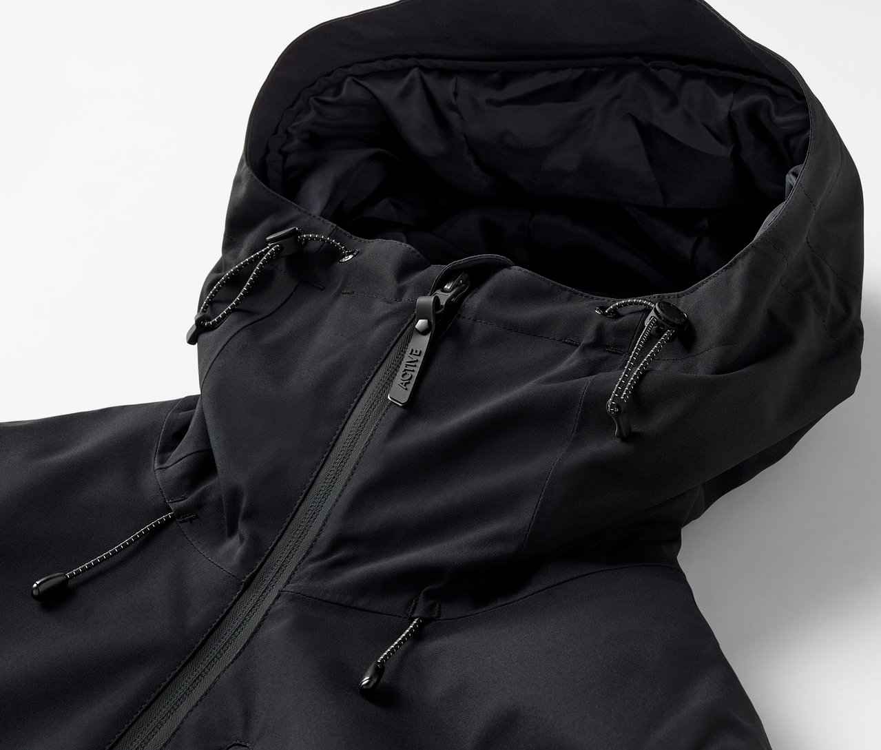 Detail černé bundy s kapucí a zipem.