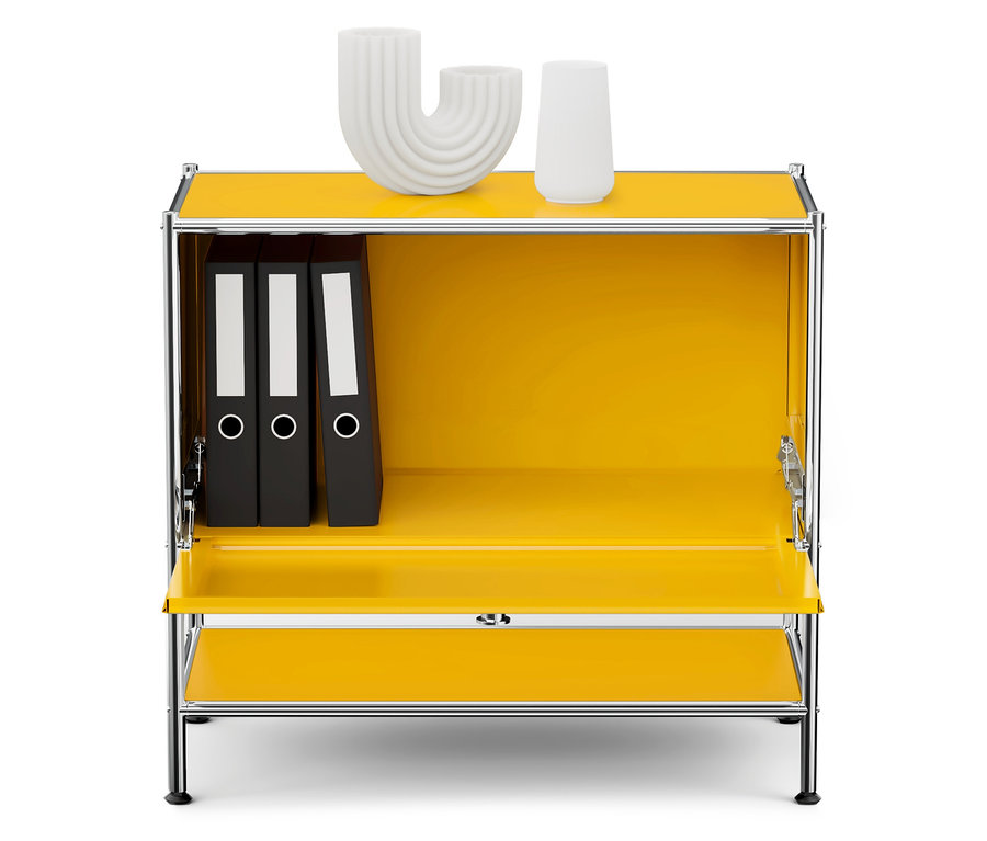 Žlutá skříňka s chromovaným rámem, uvnitř jsou tři černé pořadače a na horní desce dvě bílé dekorace.