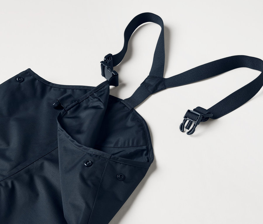 Modrá zástěra s nastavitelnými popruhy a našitou kapsou, na bílém pozadí.