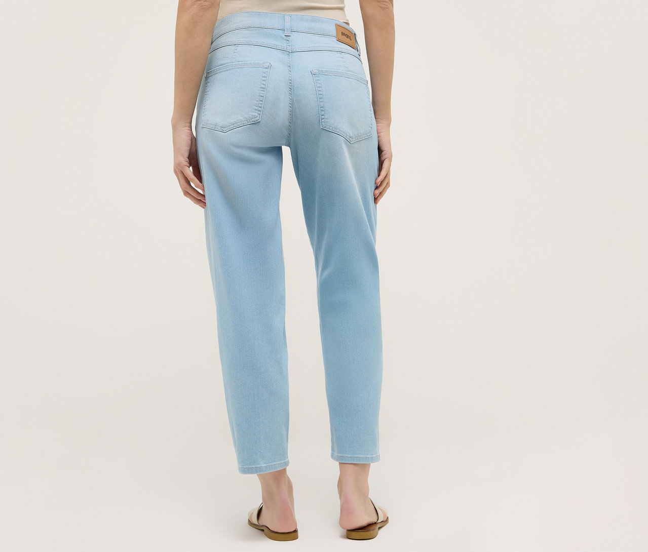 Pohled zezadu na ženu ve světle modrých džínách Angels Denim »Evy Cool« O-Shape a sandálech.