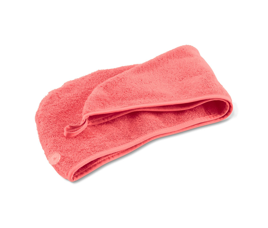 Růžový ručníkový turban na bílém pozadí.