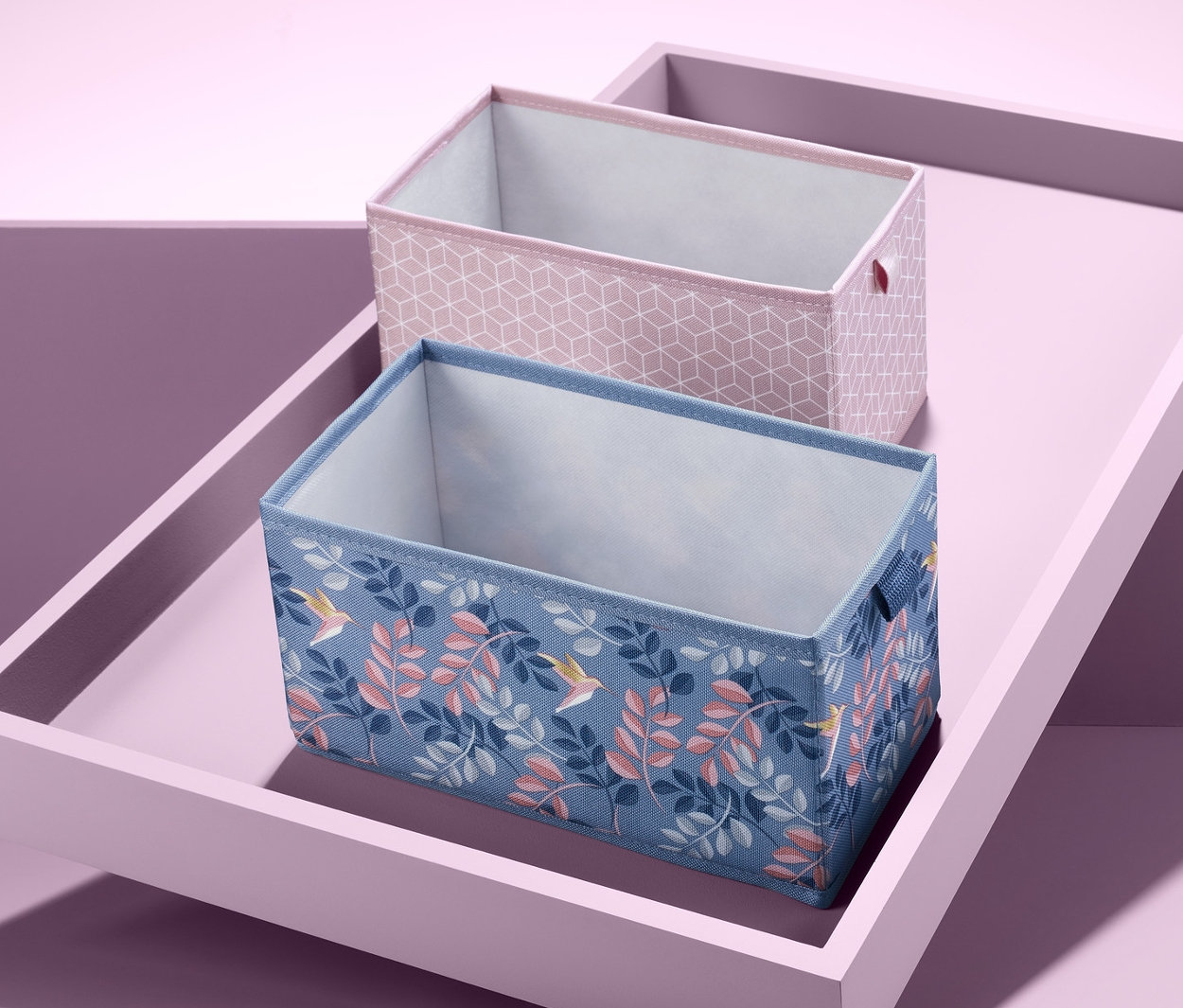 Na nakloněném podnosu leží dva obdélníkové organizéry do zásuvky.