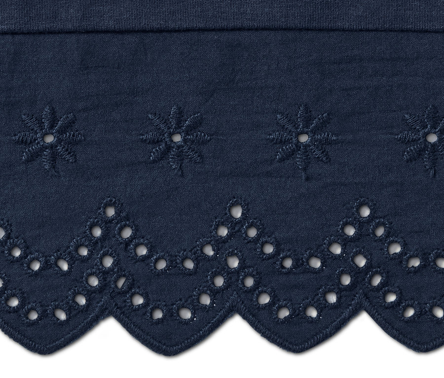 Detail modrých culotte kalhot s výšivkou.