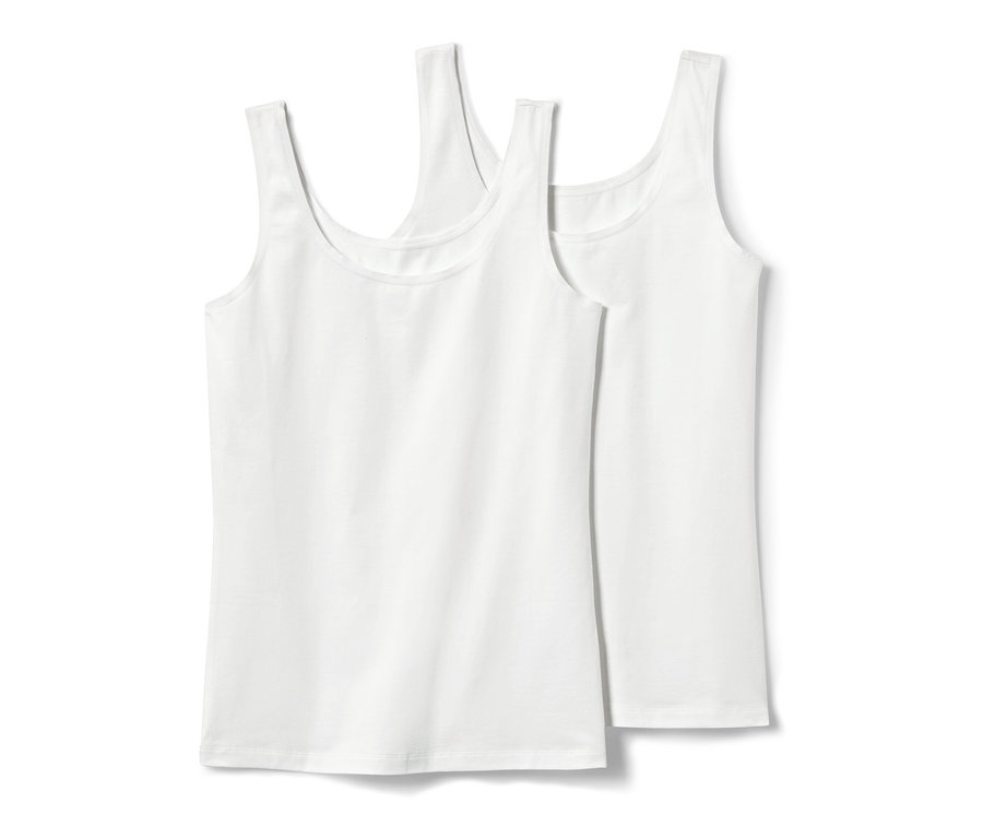 Dvě bílá tílka, 2 ks, leží na sobě.