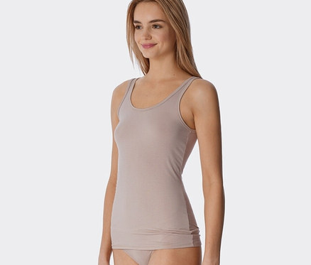 Žena má na sobě pískové proužkované tílko SCHIESSER s modalem.