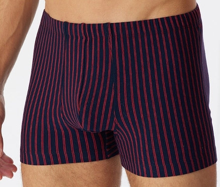 Muž nosí červené trenýrky SCHIESSER s biobavlnou.