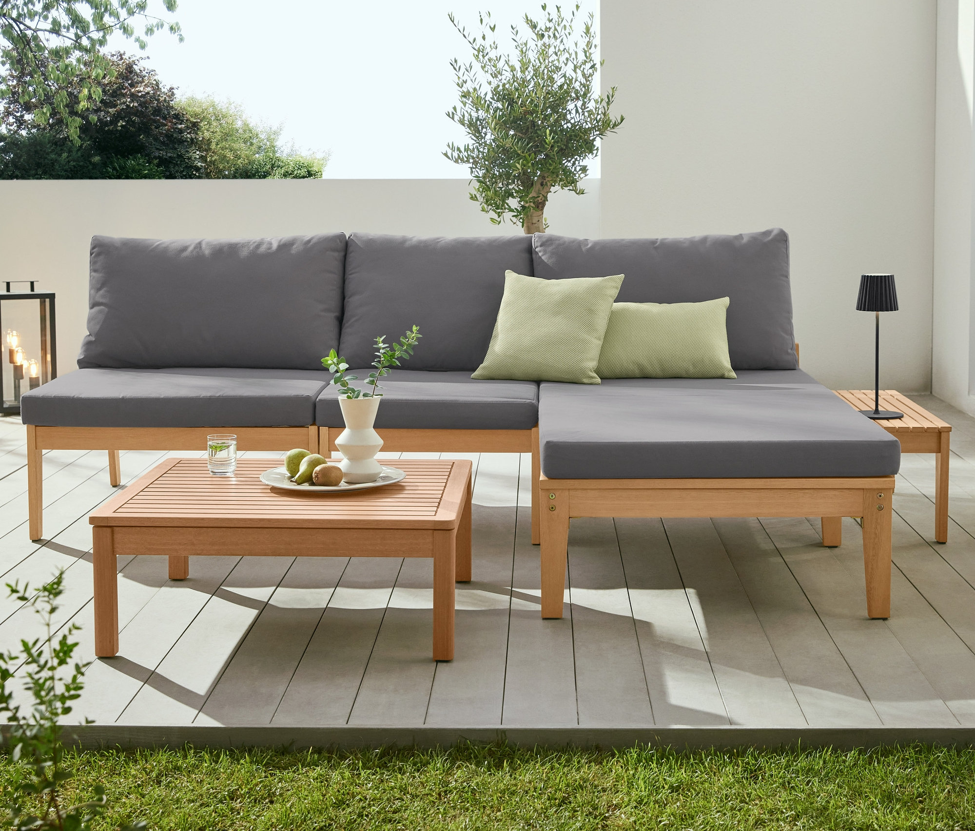 Rohová sedací souprava »Lenja«, konferenční stolek »Lenja«, konzolový stolek a LED akumulátorová stolní lampa na terase.