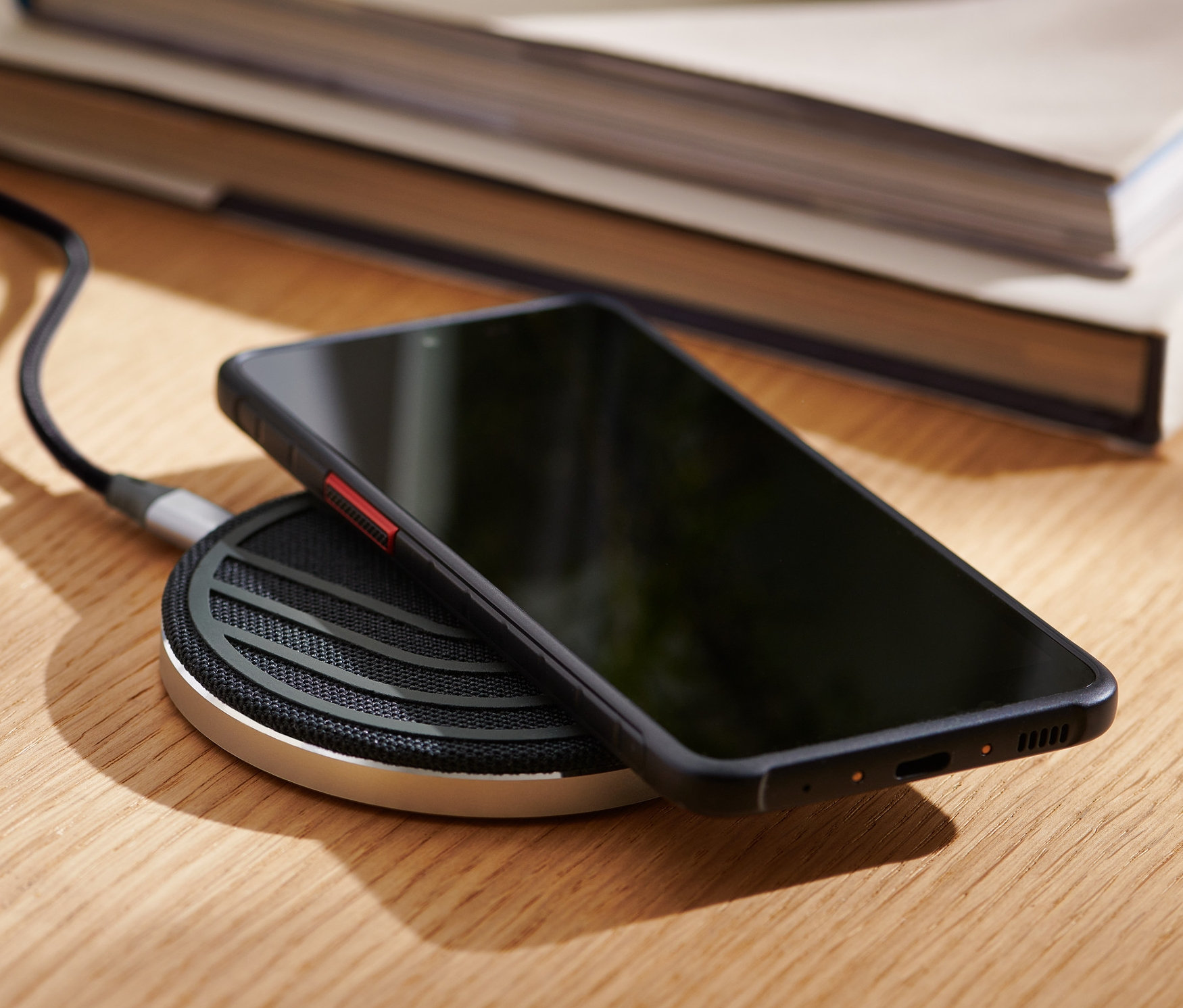 Telefon leží na bezdrátové nabíjecí stanici.