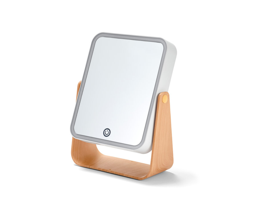 Detail kosmetického zrcátka s LED osvětlením na dřevěném podstavci.