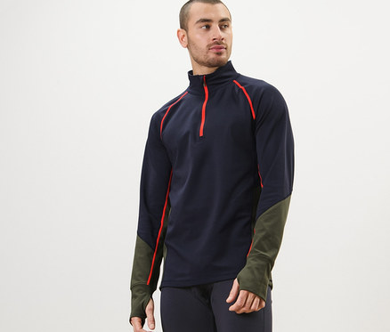 Muž má na sobě funkční termotriko, tmavě modré legíny a pózuje.