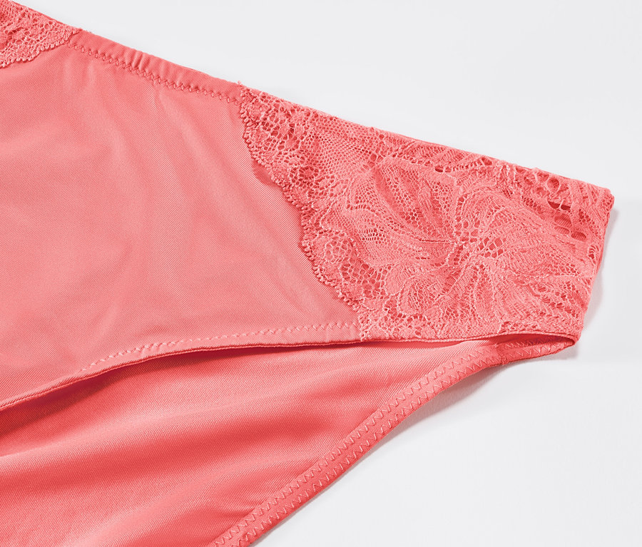 Detail kalhotek papájové barvy s krajkou.