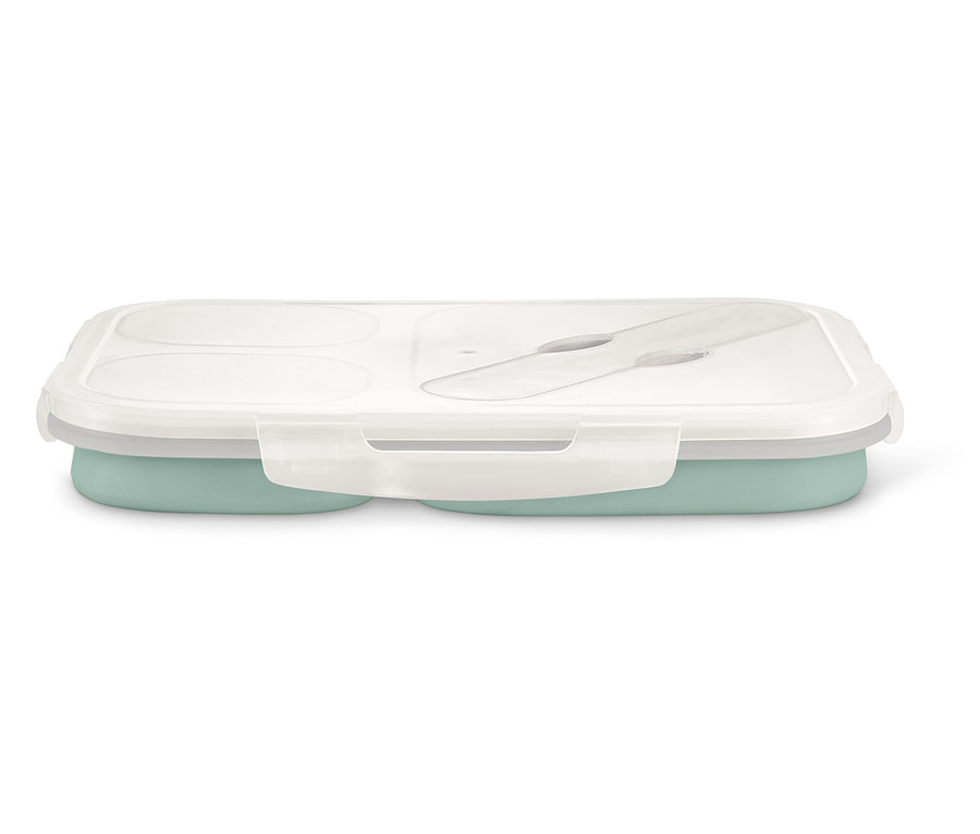 Zavřený obědový box s průhledným víkem a příborem uvnitř, spodní část je světle zelená.
