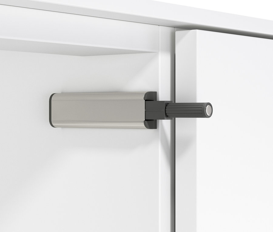 Detail bílé komody se zásuvkami.