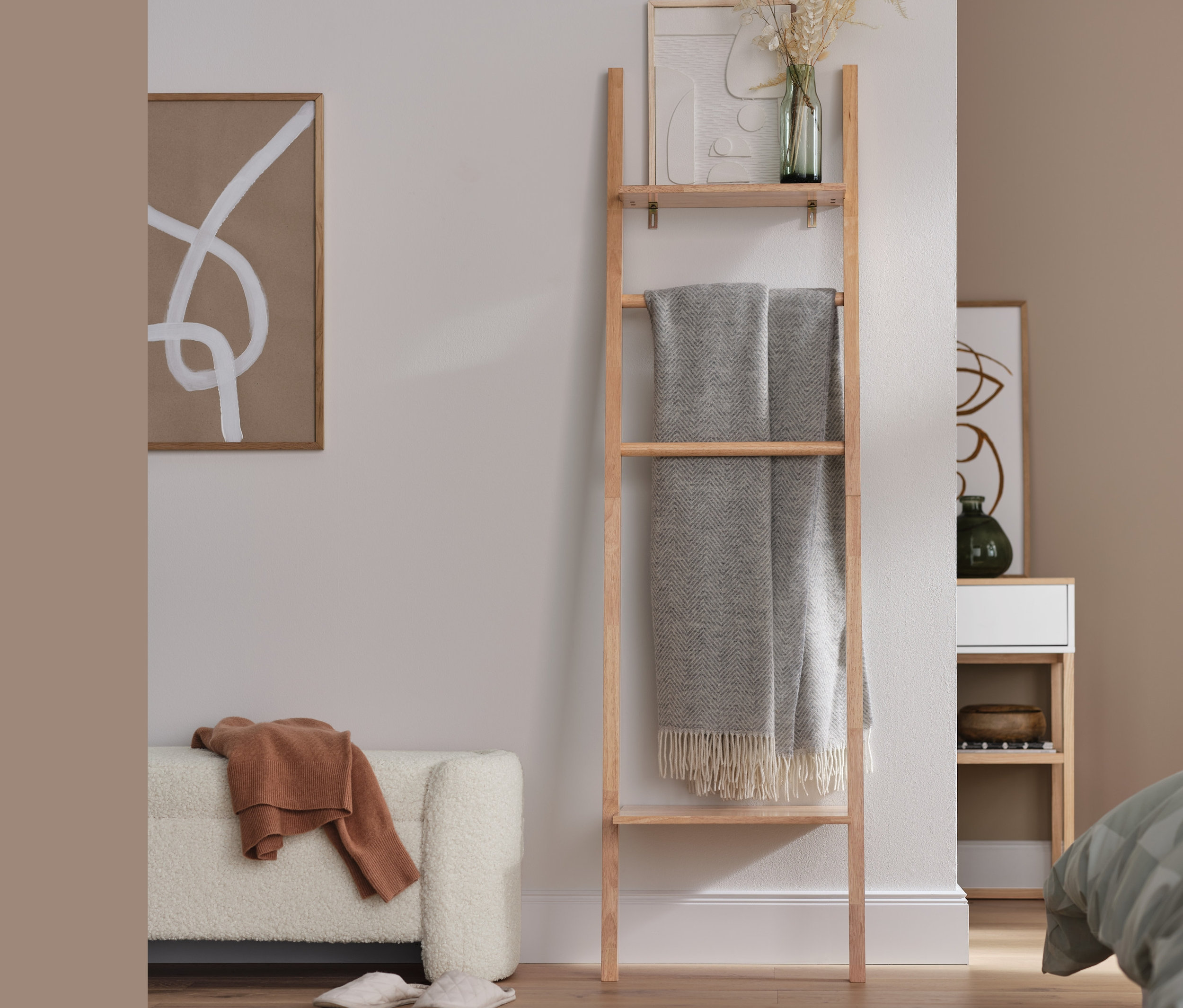 Čalouněná lavice a žebříkový regál v obývacím pokoji.