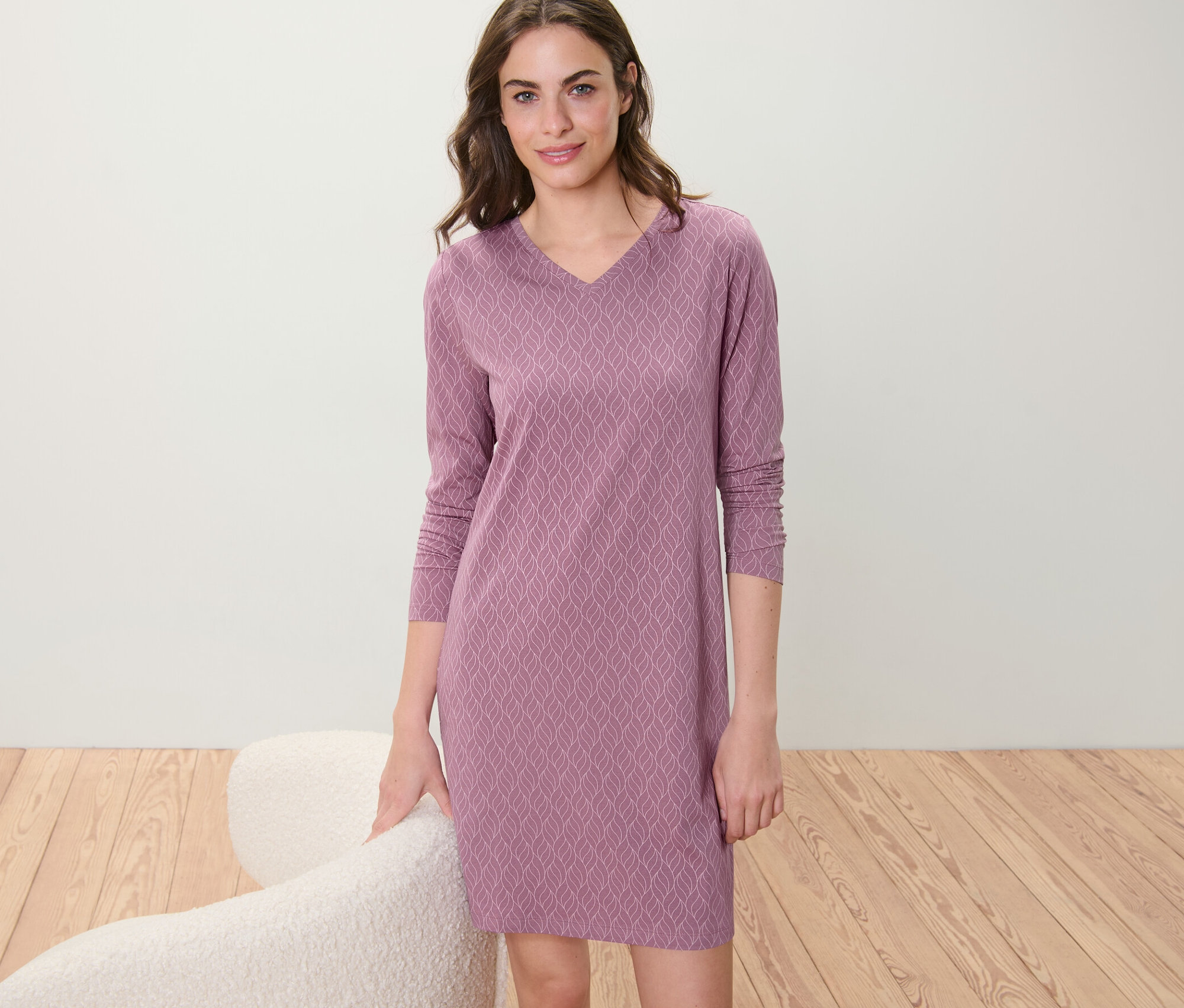 Žena pózuje v noční košili.