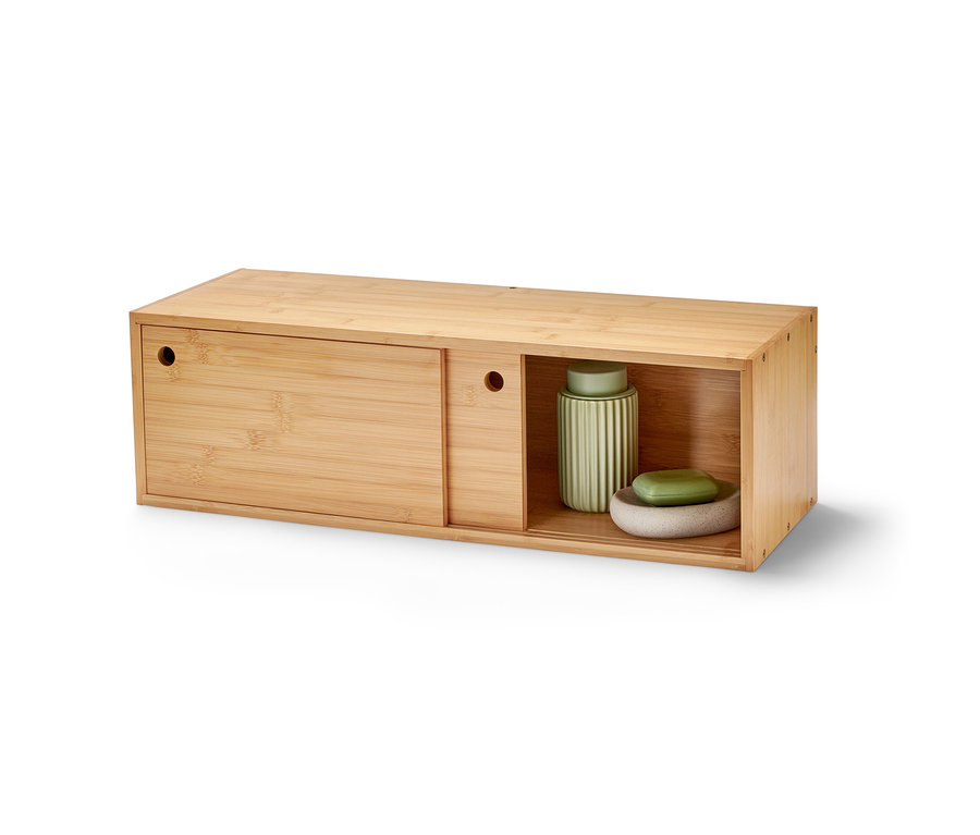 Nástěnný regál s posuvnými dvířky z bambusu. V otevřené části je zelená váza a miska se zeleným mýdlem.