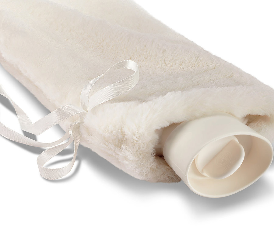 Dlouhý termofor v bílém chlupatém obalu a se stuhou.