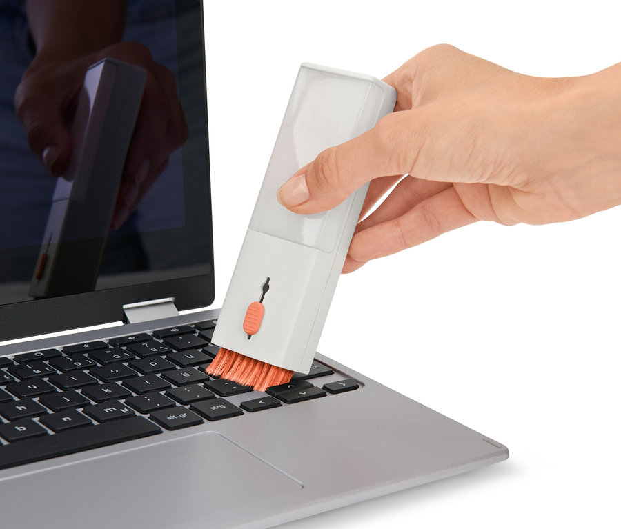 Ruka čistí klávesnici notebooku pomocí sady na čištění psacího stolu 4 v 1.