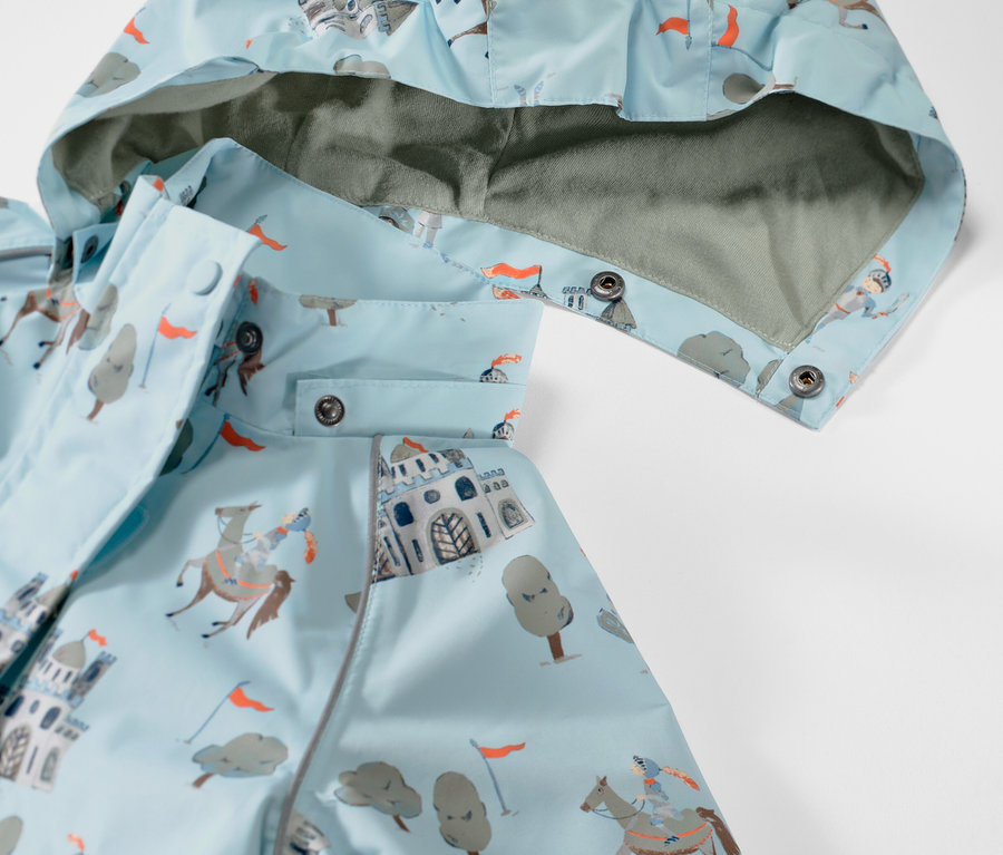 Detail dětské bundy do deště s motivem rytíře.