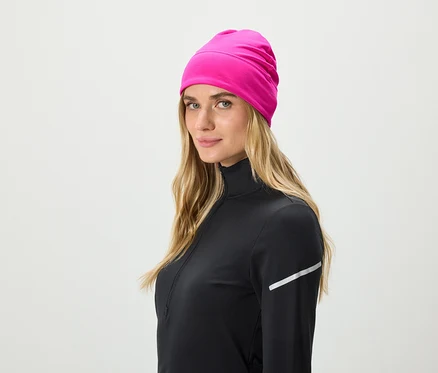 Blondýna v černém sportovním topu s růžovou čepicí.