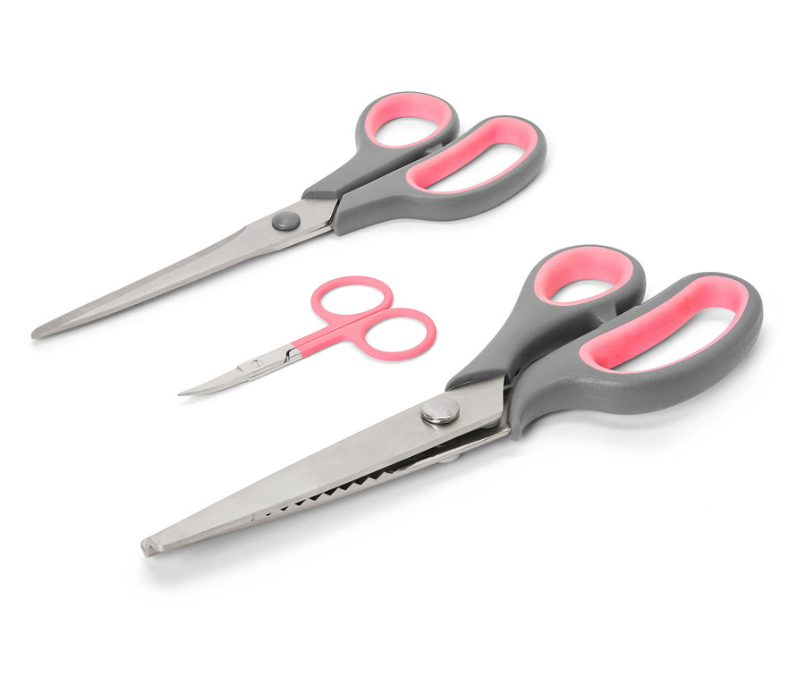 Sada nůžek na textil s šedými rukojeťmi a růžovými vnitřky na bílém pozadí.