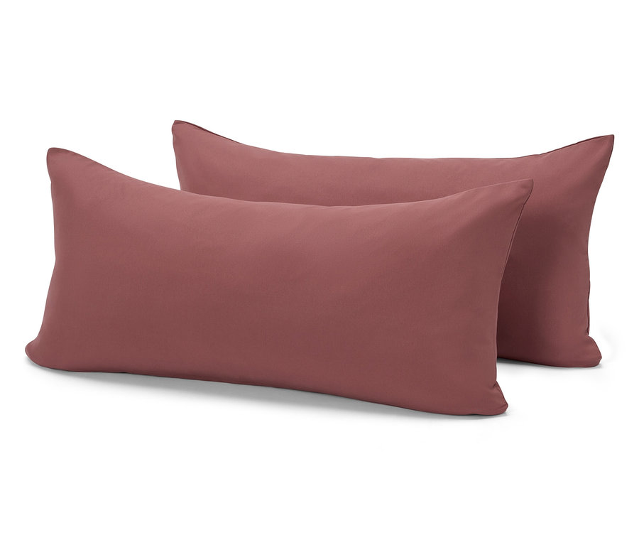 Dva obdélníkové polštáře cihlové barvy leží na sobě na bílém pozadí.