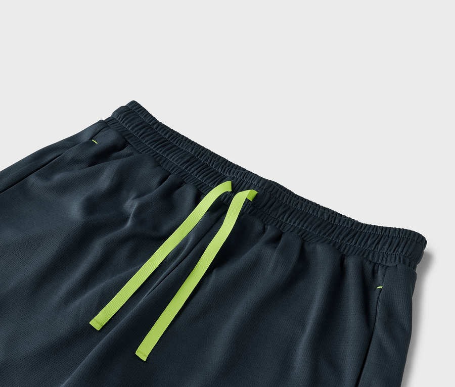 Detail tmavě šedých šortek se světle zelenou stahovací šňůrkou.