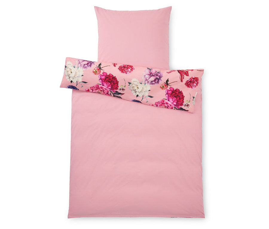 Pohled shora na růžový povlak na přikrývku a povlak na polštář, přičemž povlak na polštář a horní polovina povlaku na přikrývku mají květinový vzor.