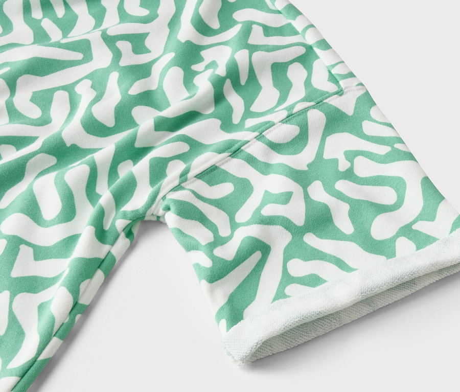 Detail oděvu se zeleno-bílým vzorem.