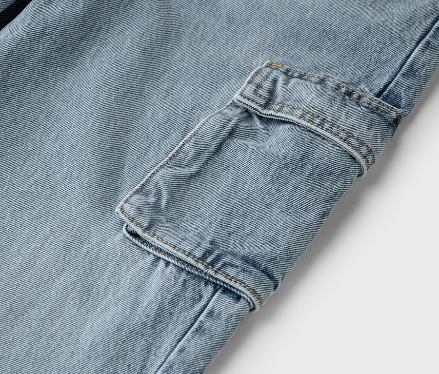 Detail světle modrých džínů s cargo kapsou.