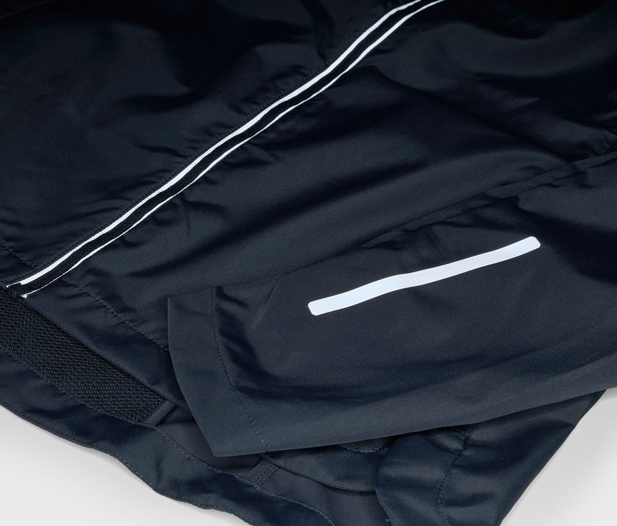 Detail černé bundy s bílými pruhy.