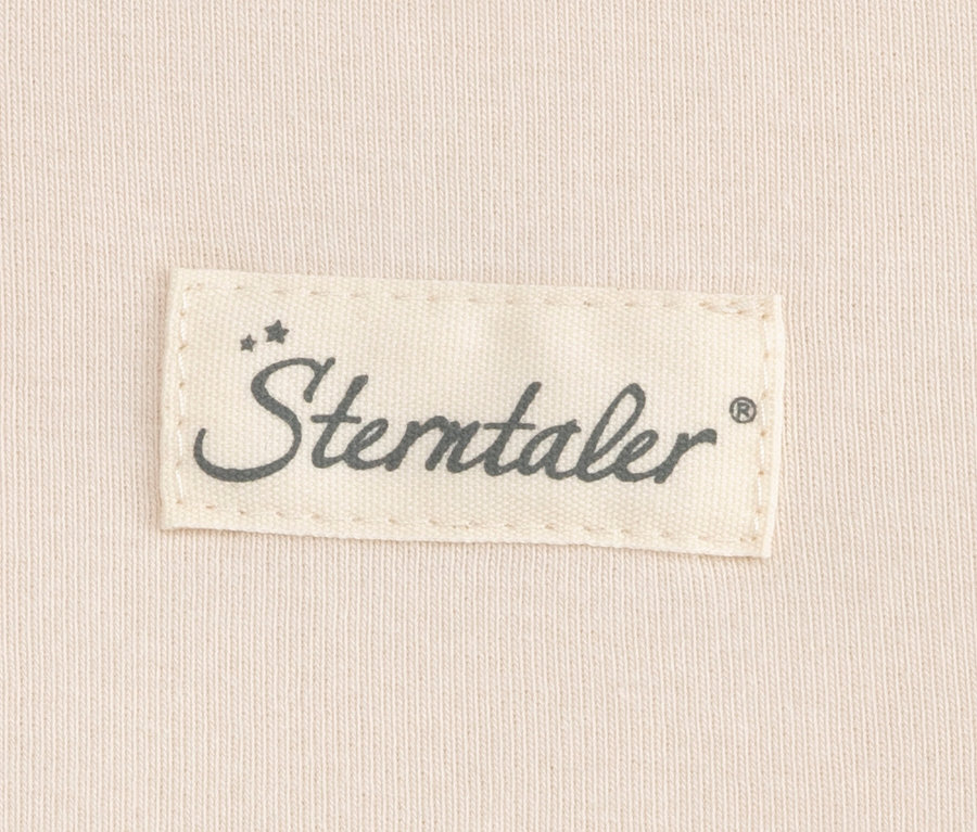 Štítek značky „Sterntaler“ na světle béžové látce, pravděpodobně z vnitřního spacího pytle pro miminka.